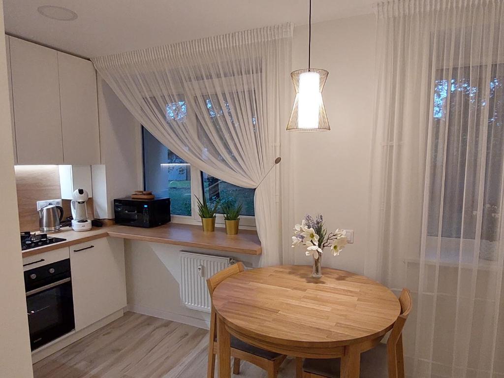 a kitchen with a wooden table and a dining room at DIVA contactless check in & out in Šiauliai