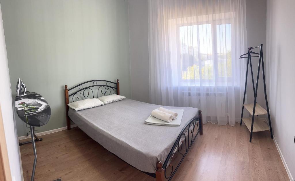 a bedroom with a bed and a window at Уютная и комфортная 3х комнатная квартира со всеми условиями in Uralsk