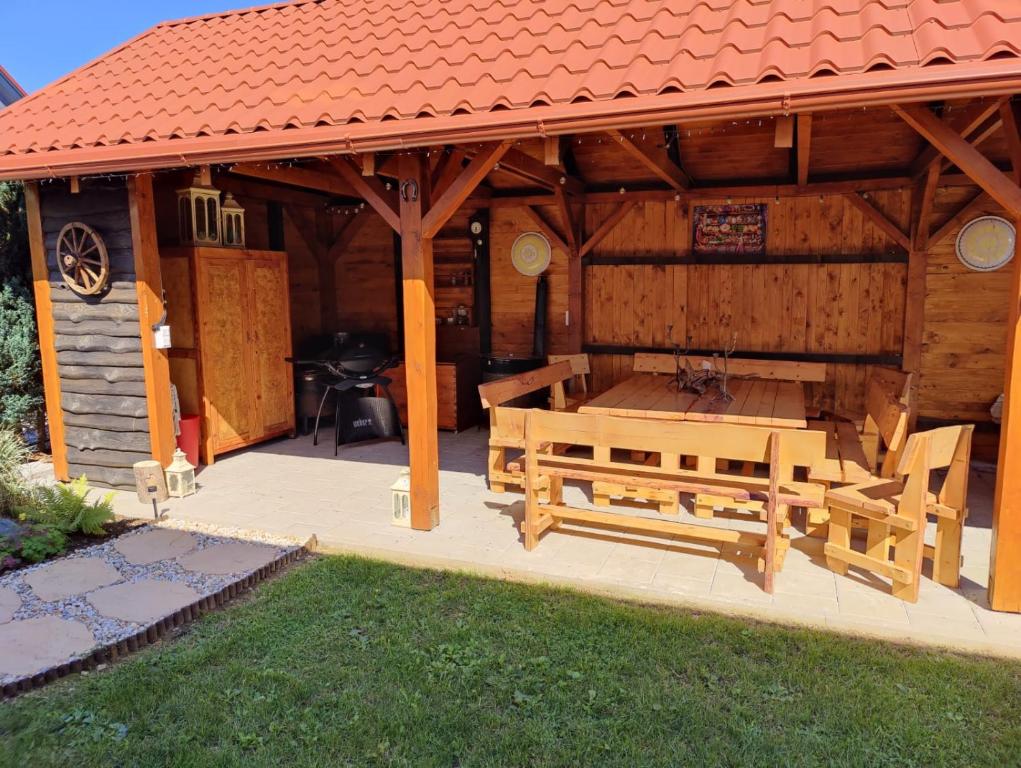 un gran pabellón de madera con mesa y bancos en Nest, en Spišská Nová Ves