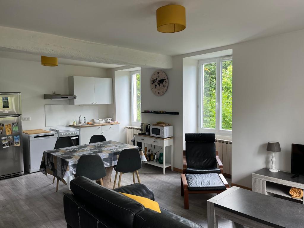 eine Küche und ein Wohnzimmer mit einem Tisch und Stühlen in der Unterkunft L’Annexe in Chantelle