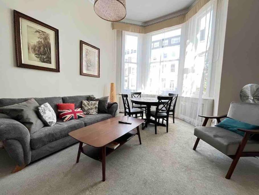 - un salon avec un canapé et une table dans l'établissement Wonderful apartment in Earl’s Court, à Londres