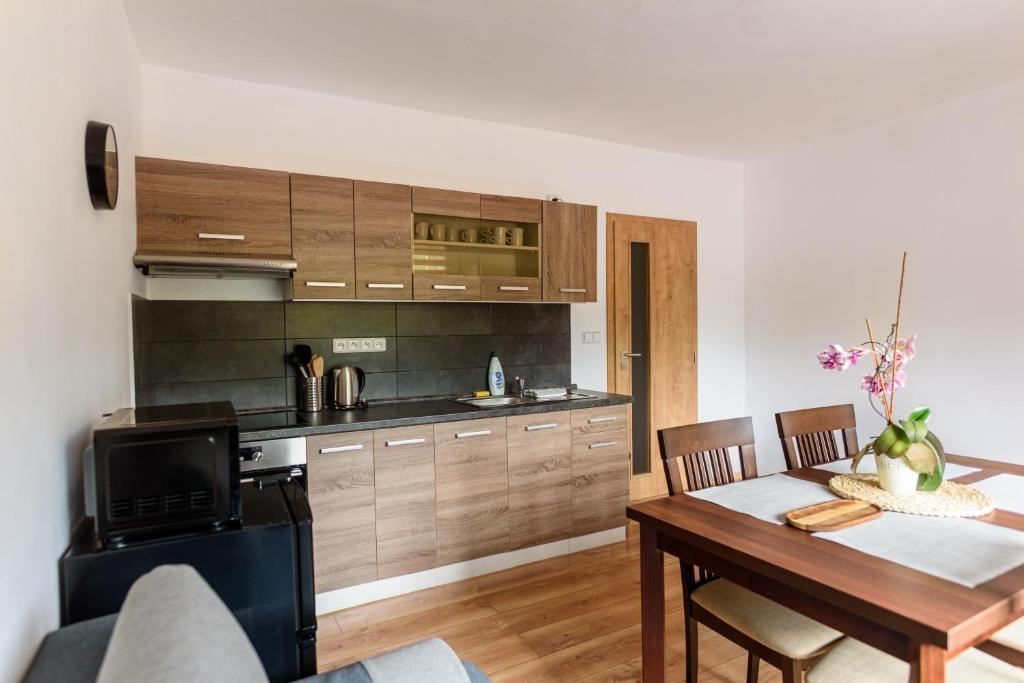a kitchen and dining room with a table and a stove at Apartmány Slavíkov - Country Suite in Horní Radechová