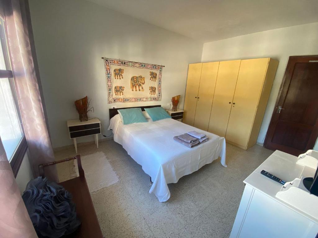 - une chambre avec un lit blanc et une commode dans l'établissement Casa Quintilia, à Los Llanos de Aridane