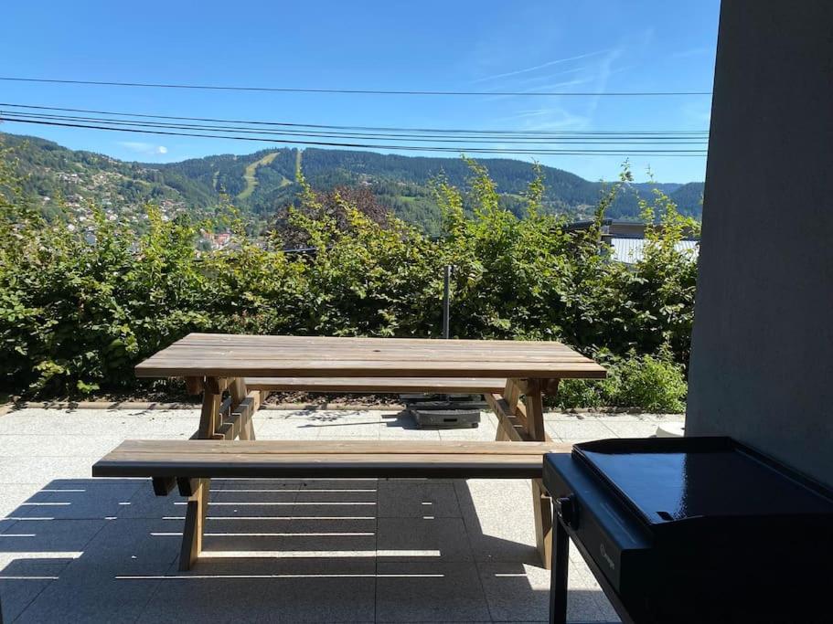 a wooden picnic table with a view of a mountain at Appartement Gérardmer in Gérardmer