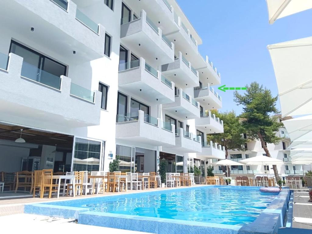 a hotel with a swimming pool in front of a building at Diamond DREAM in Sarandë