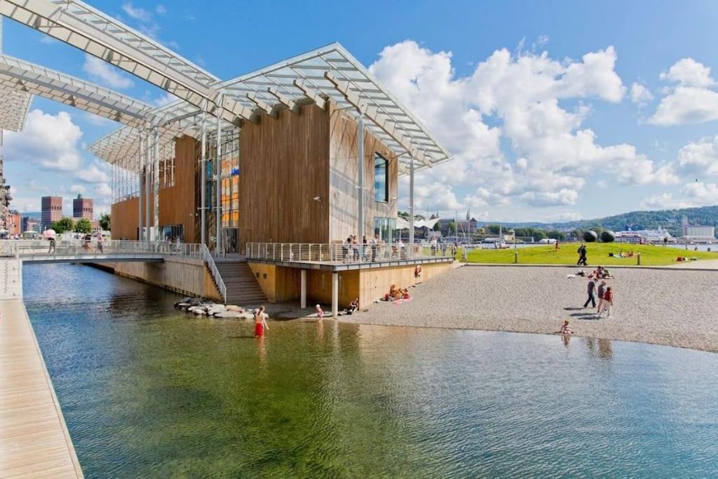 Aker Brygge - Sjøside hjem - Sentral beliggenhet في أوسلو: عمل بناء بجانب تجمع للمياه