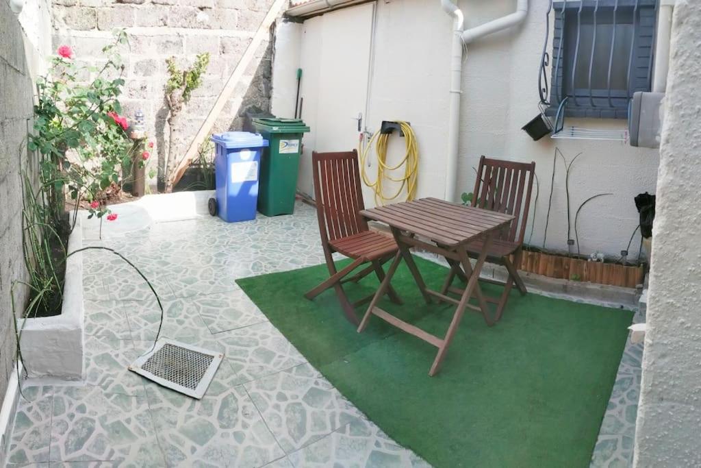 einen Tisch und zwei Stühle sowie einen Laptop auf einer Terrasse in der Unterkunft Petite maison à Drancy in Drancy