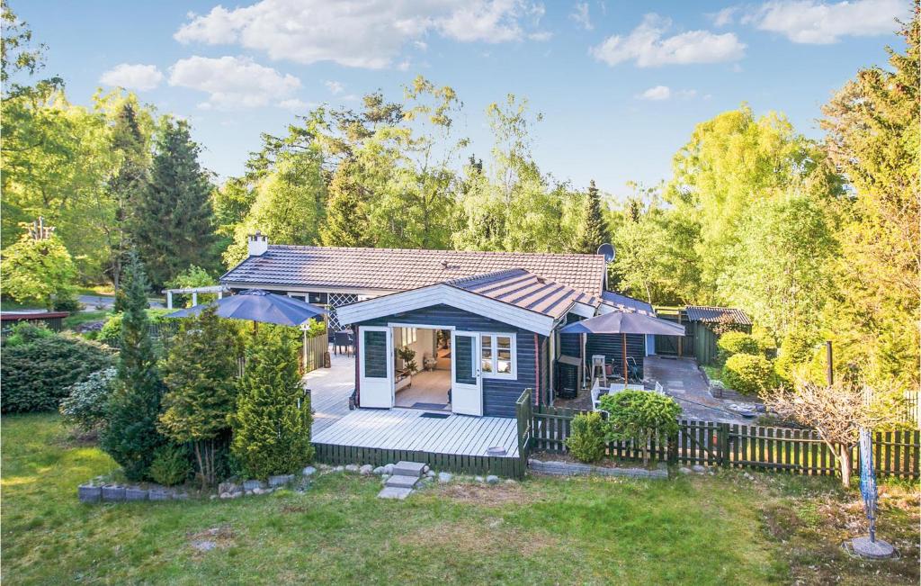 una pequeña casa azul con una valla en un patio en Nice Home In Rrvig With 3 Bedrooms And Wifi, en Rørvig