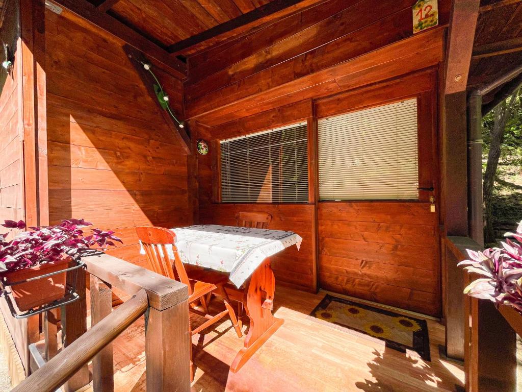 a porch of a wooden cabin with a table and chairs at Le sorgenti - Chalet 12 in Palazzuolo sul Senio