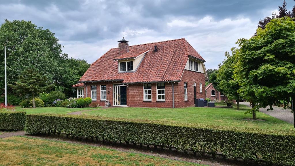a red brick house with a red roof at B & B de Vlegge in Sibculo