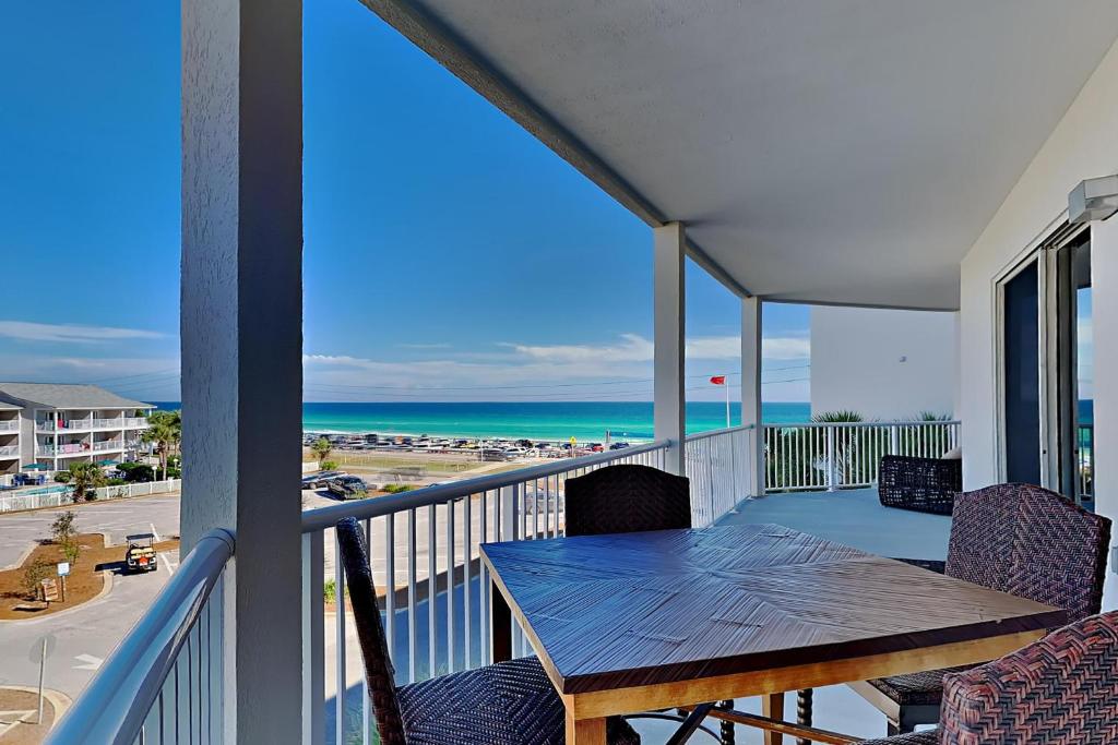 a balcony with a table and chairs and the beach at Crystal View #303 in Destin