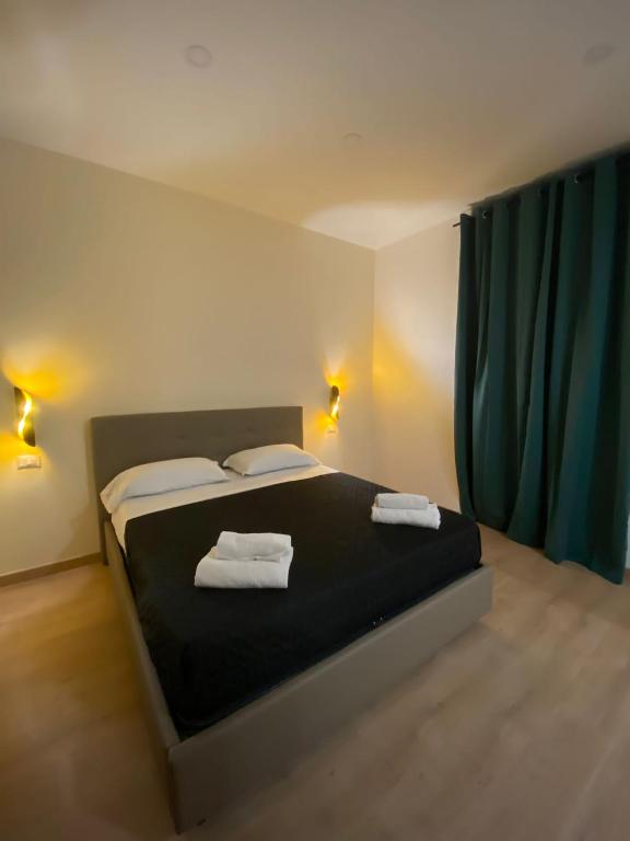 a bedroom with a bed with two towels on it at Maison Dante in Naples
