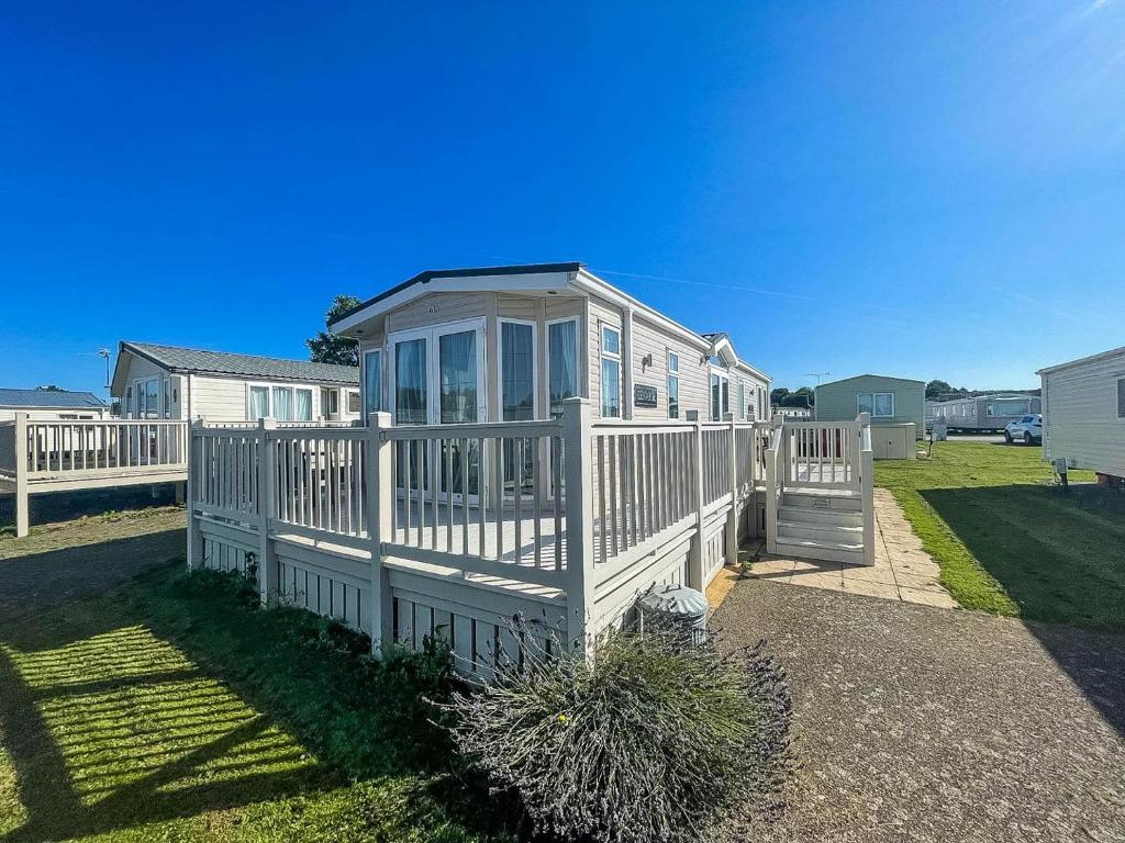 a large white house with a porch at Lovely Caravan With Decking At Manor Park, Near Hunstanton Beach Ref 23034c in Hunstanton