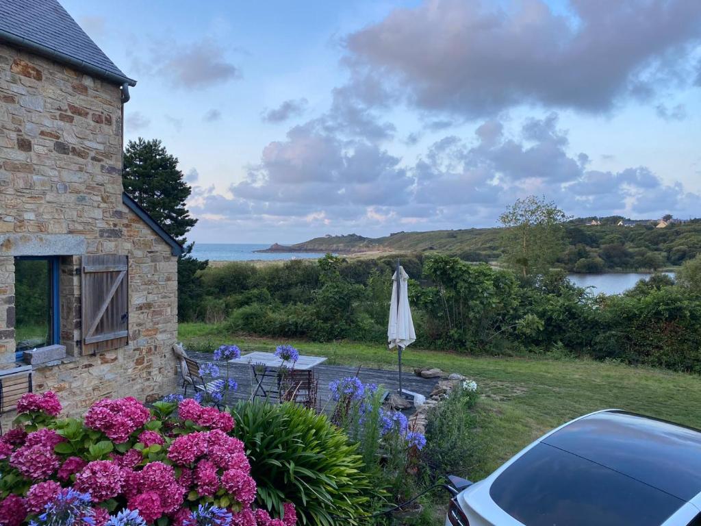 カンカルにあるCancale Chapelle du Vergerのテーブルと傘と花を持つ家