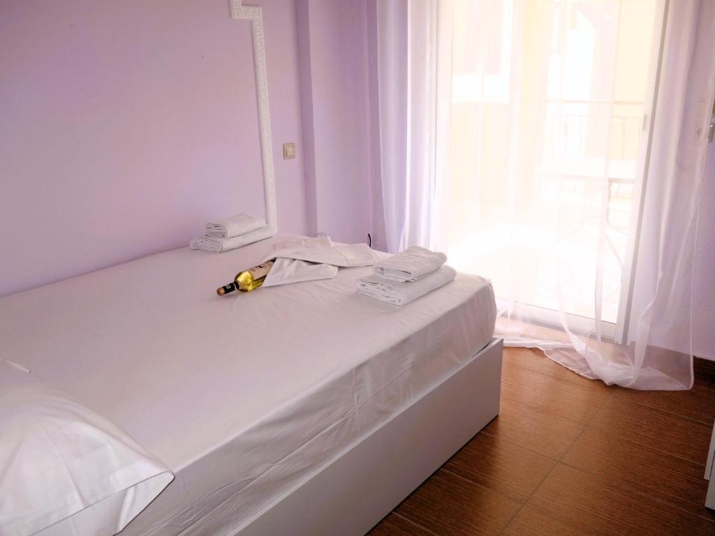 a white bedroom with a bed with a banana on it at HOUSE ALLA in Pefkohori