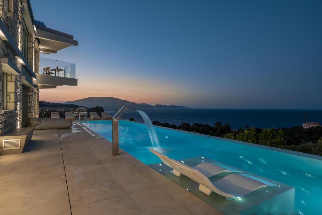 a swimming pool with a chair next to a building at Sky Birds Villa - Holistic Escape in Skinária