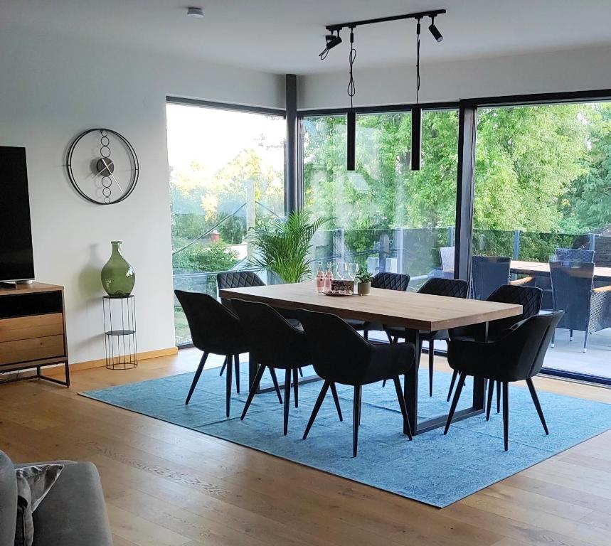 a dining room with a table and chairs on a rug at Luxuriöses Penthouse mit Blick auf die UNO-City und dem Kaiserwasser. 3Schlafzimmer, 2 Bäder, privat Lift ins Apartment in Vienna