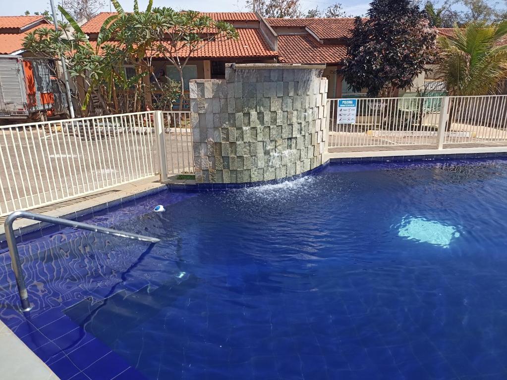a large blue swimming pool with a white fence at CASA em CALDAS NOVAS in Caldas Novas