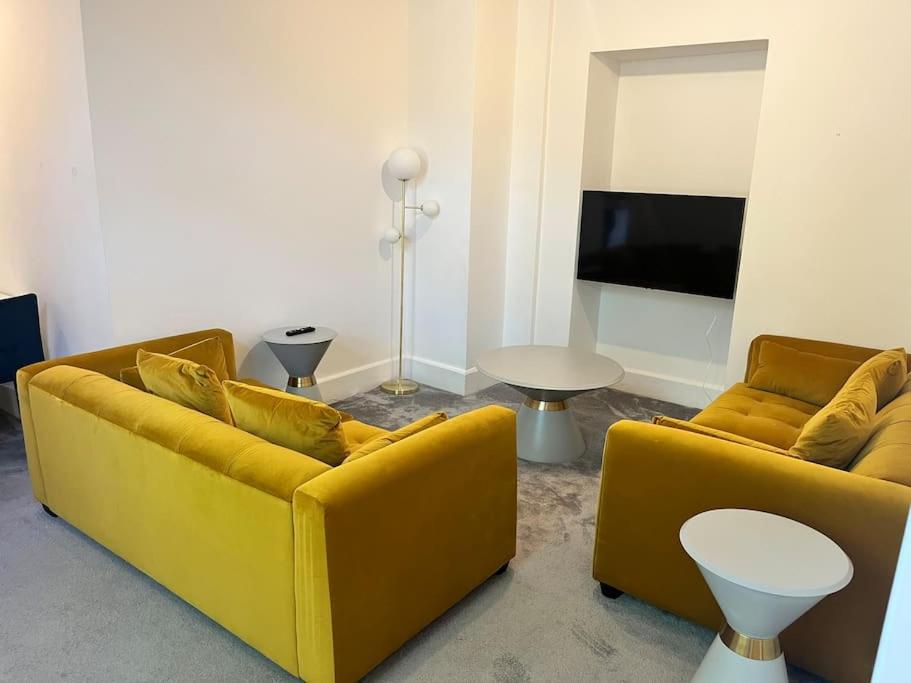 a living room with two yellow couches and a table at The Mews, private parking included, Windermere in Windermere