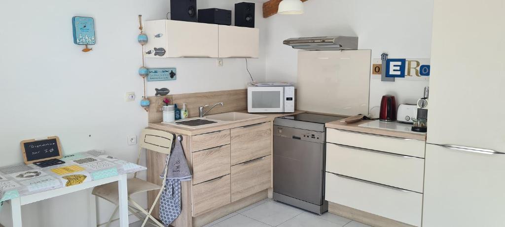 a small kitchen with a sink and a refrigerator at La Remigeasse in Dolus-d&#39;Oléron