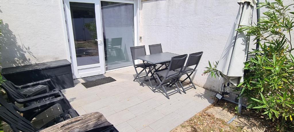 a patio with a table and chairs in front of a house at La Remigeasse in Dolus-d&#39;Oléron