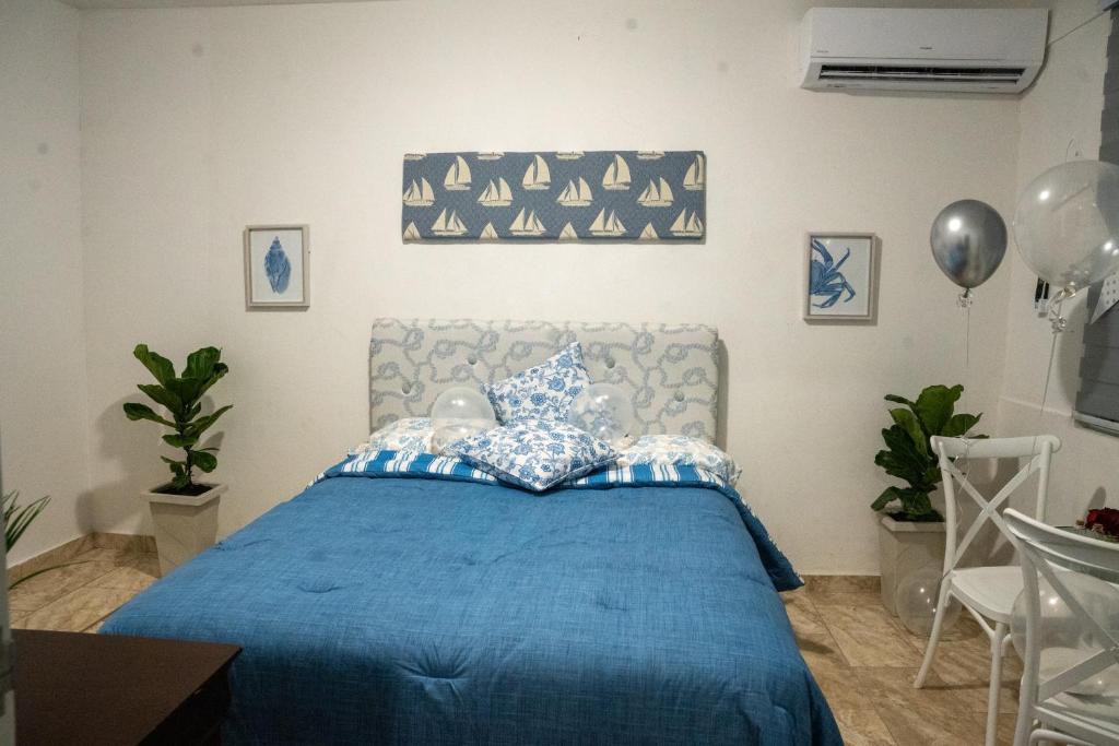 a bedroom with a blue bed with a blue comforter at Casa Maria Luquillo PR in Luquillo