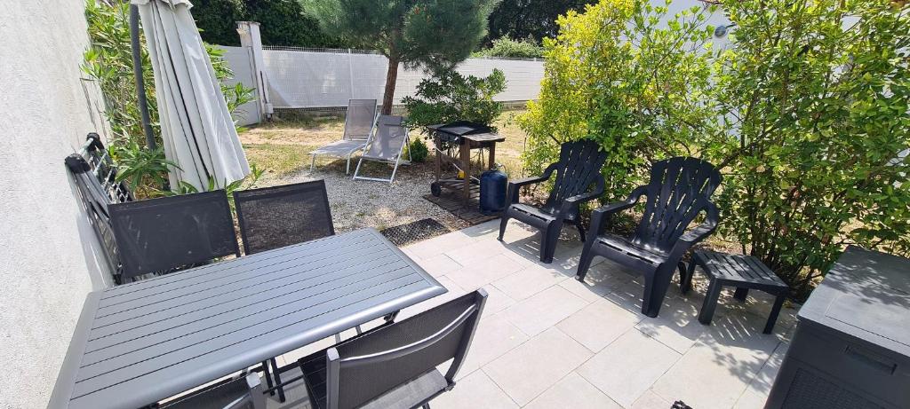 a patio with chairs and a table and a table and chairs at La Remigeasse in Dolus-d&#39;Oléron