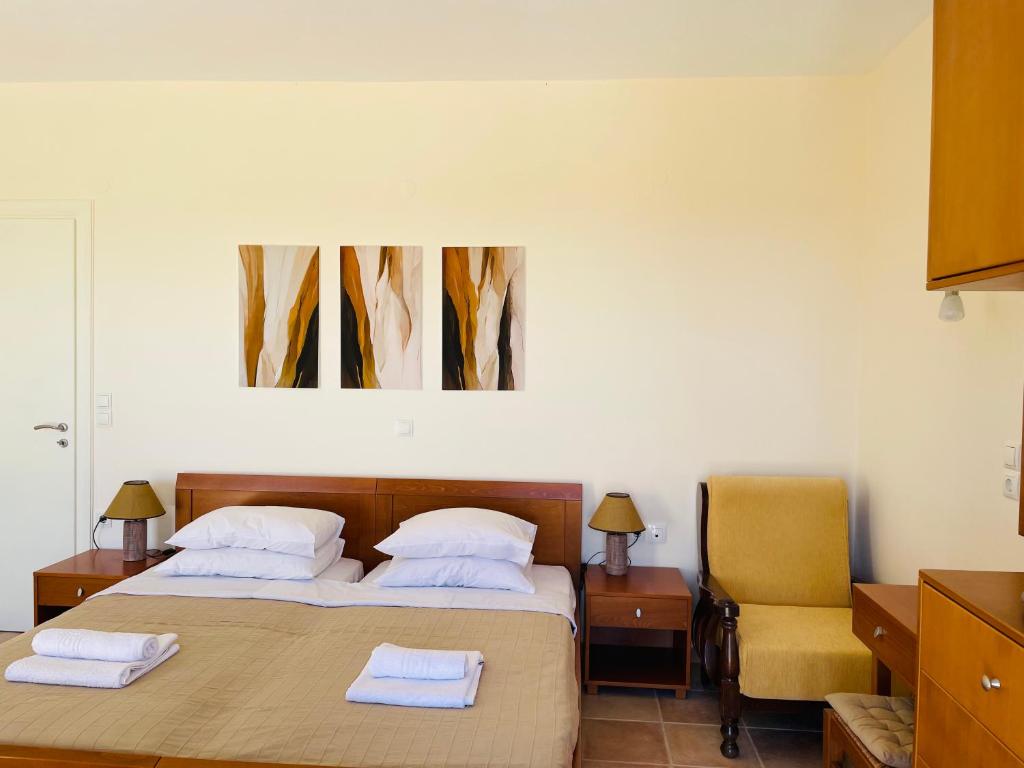 ein Schlafzimmer mit 2 Betten und einem gelben Stuhl in der Unterkunft Princess Of Crete in Skaleta