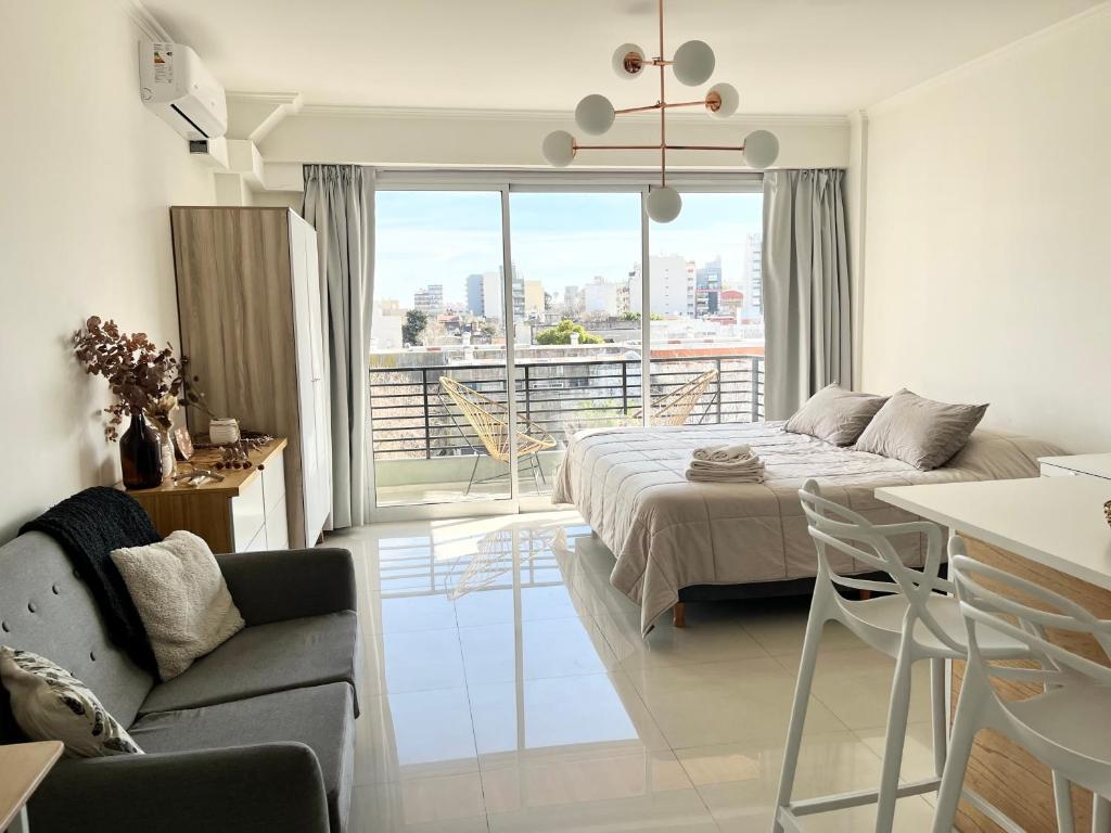 1 dormitorio con 1 cama y sala de estar con balcón. en Monoambiente Luxury en Buenos Aires