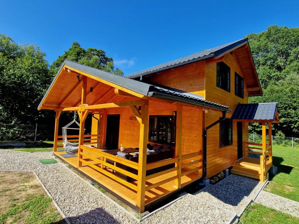 a large wooden house with a large porch at Casa Emmara Sighisoara in Daneş