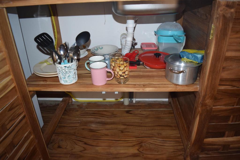 a shelf in a kitchen with dishes and utensils at Bungalows Ayampe in Ayampe