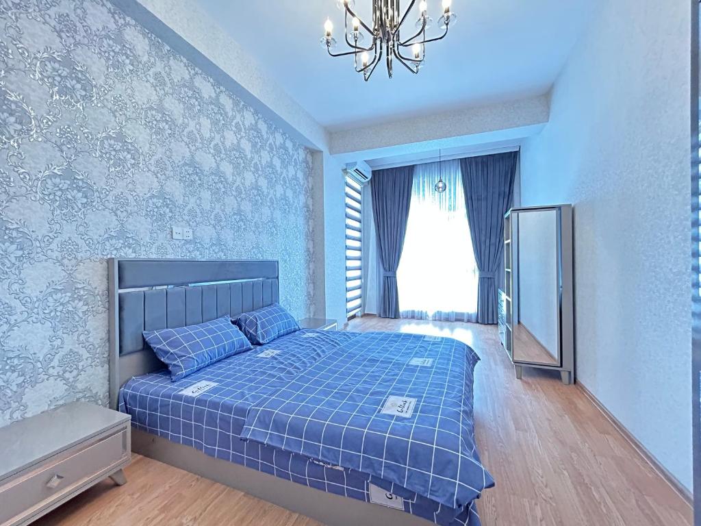 Dormitorio azul con cama y lámpara de araña en White Stone Residence 47 en Bakú