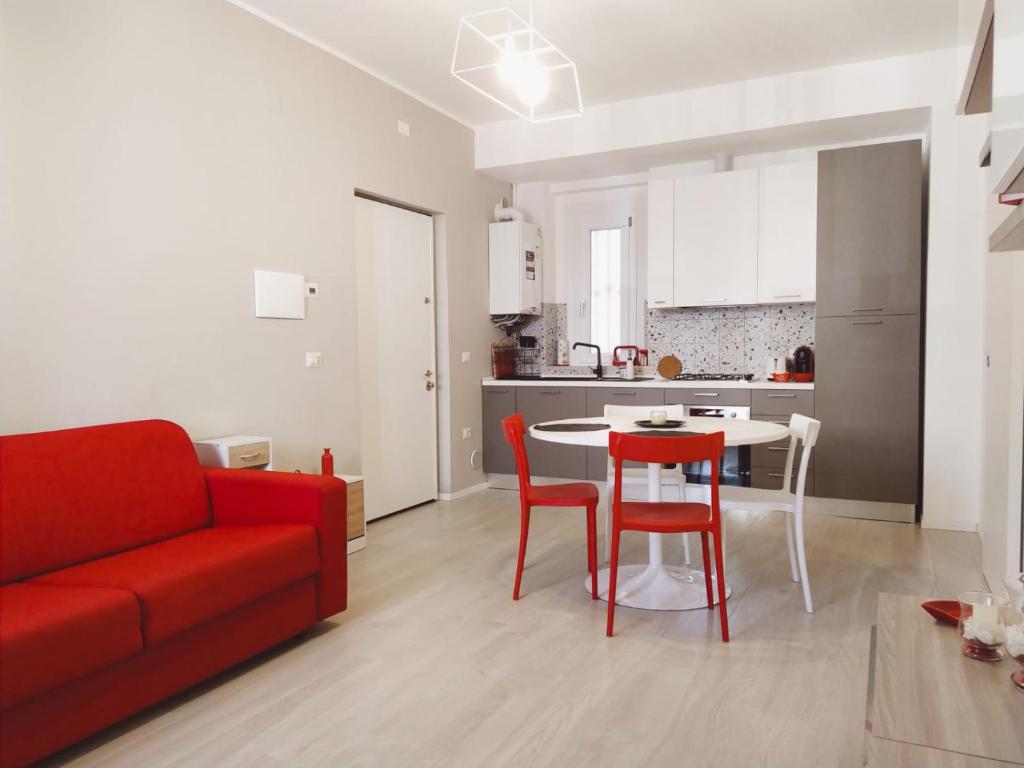 a living room with a red couch and a table and chairs at Modern Central Apartment in Grottammare