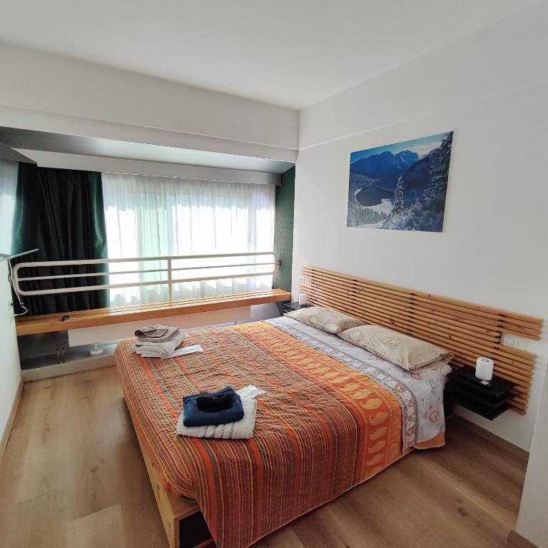 sypialnia z dużym łóżkiem i oknem w obiekcie Genziana Apartment w mieście Marilleva