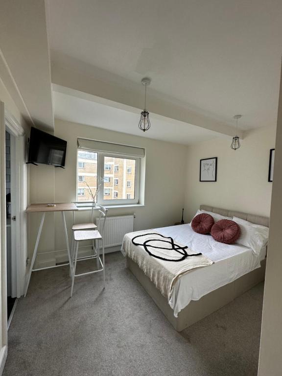 ロンドンにあるCentral studioflat Chelseaのベッドルーム1室(ベッド1台、デスク、窓付)