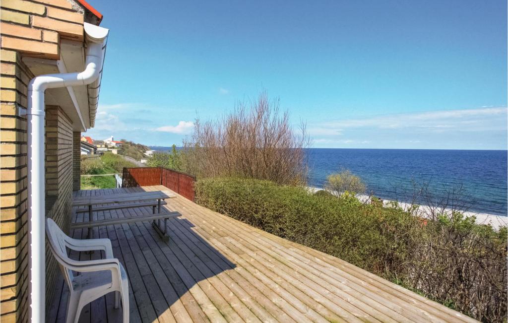 een houten terras met een bank en de oceaan bij Stunning Home In Sjllands Odde With Kitchen in Yderby