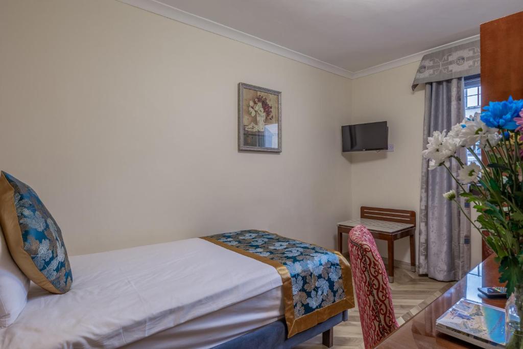 Postel nebo postele na pokoji v ubytování Muthu Fort William Hotel