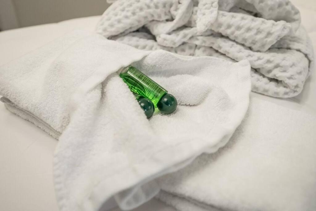 een groene fles bovenop een witte handdoek bij Cucchiari Suite 1A in Modena