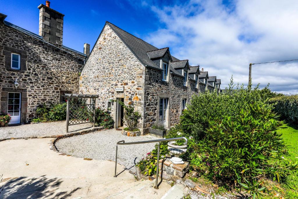 un antiguo edificio de piedra con un montón de ventanas en La Villa Bel Air, en Flamanville