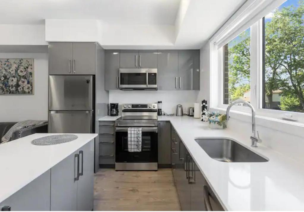 cocina con electrodomésticos de acero inoxidable y ventana grande en Luxury Suite 4mins To Falls, en Niagara Falls