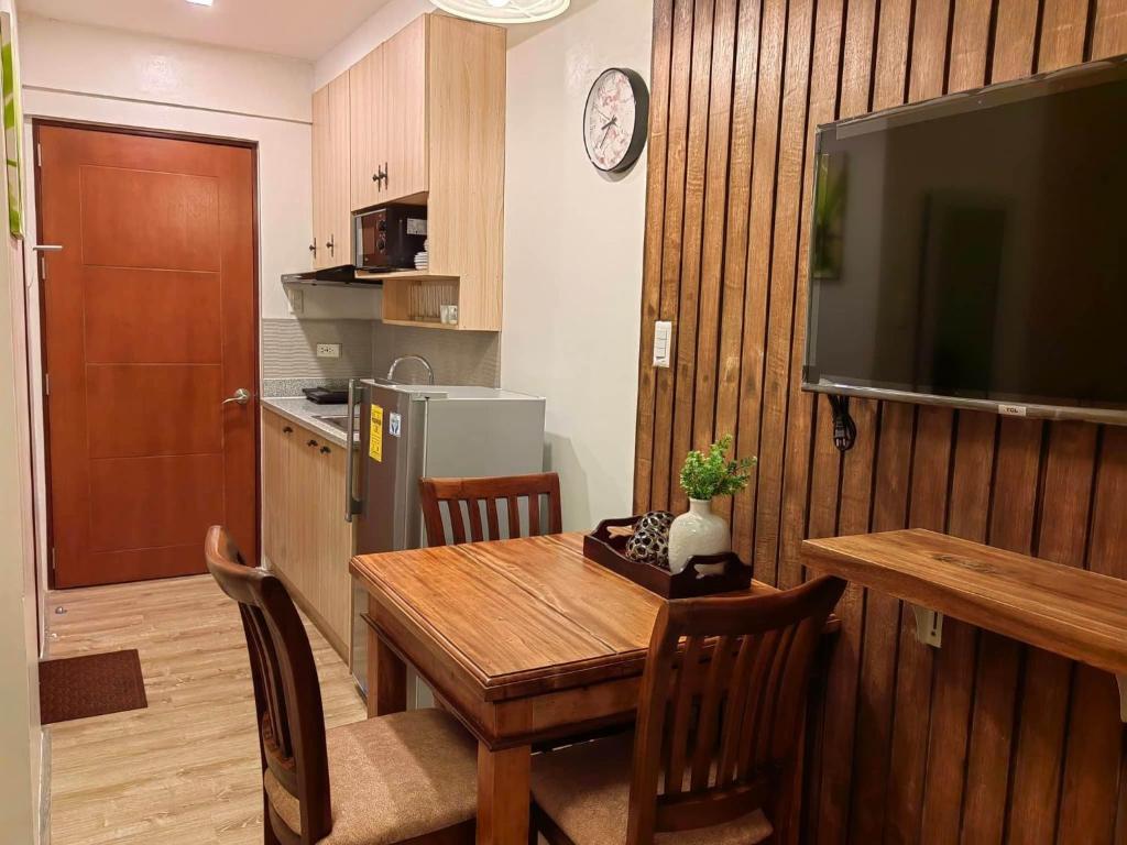 a kitchen and dining room with a table and a television at 3 J's STAYCATION in Bacolod