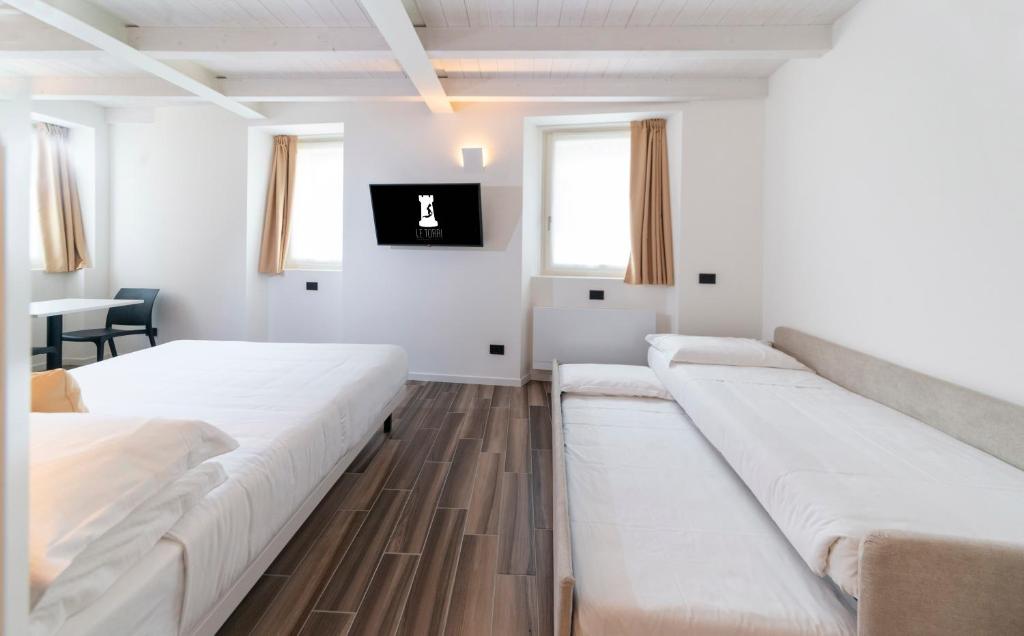 Cette chambre comprend deux lits et un canapé. dans l'établissement LE TORRI LOVERE, à Lovere