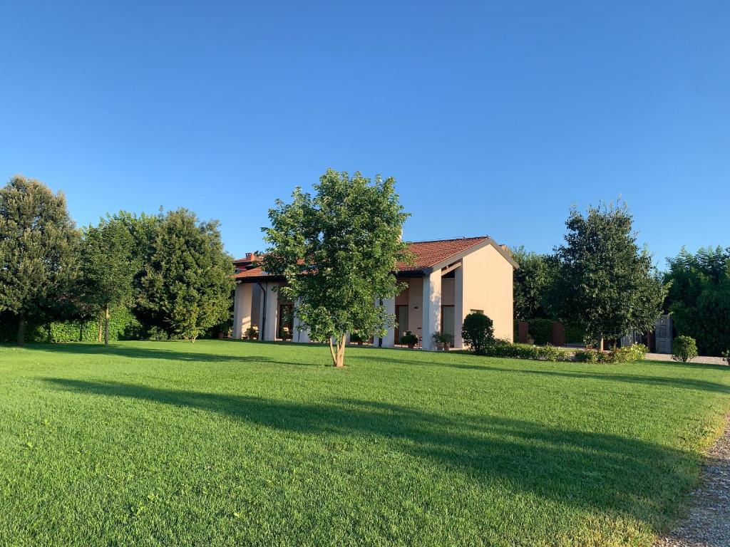 a house with a tree in the middle of a yard at Agriturismo Ca' Giulietta in Sommacampagna