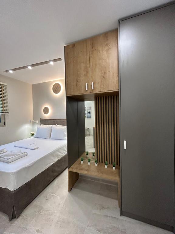 a bedroom with a large bed and a wooden cabinet at Armonía Small Luxury Apartments in Ierápetra