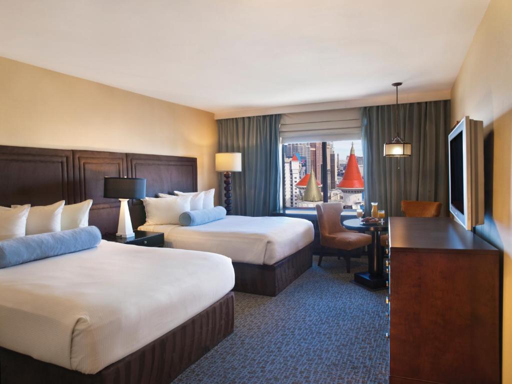 a hotel room with two beds and a television at Beddable Unit by The Excalibur Casino Las Vegas STRIP in Las Vegas