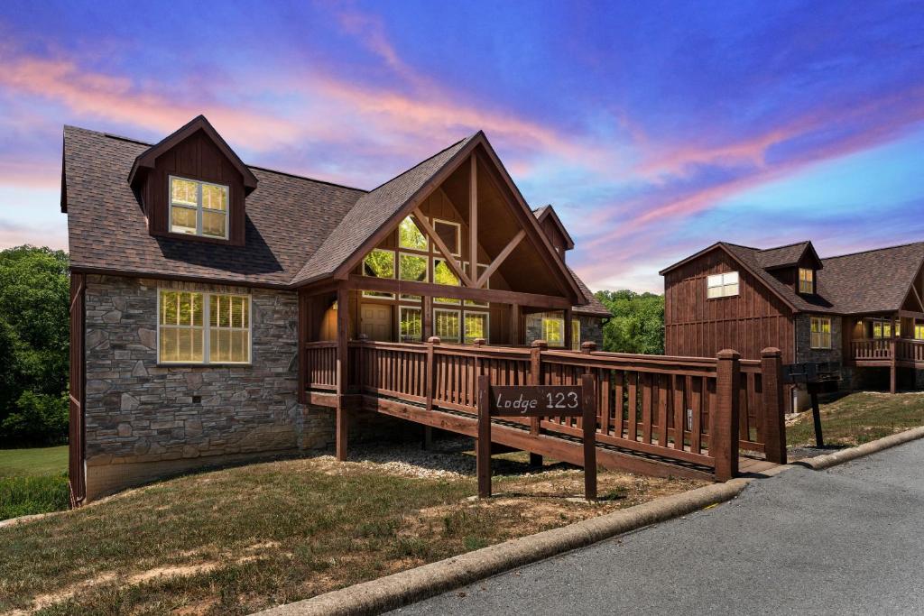 a large house with a wooden fence in front of it at Makin Memories Lodge Cabin in Branson West