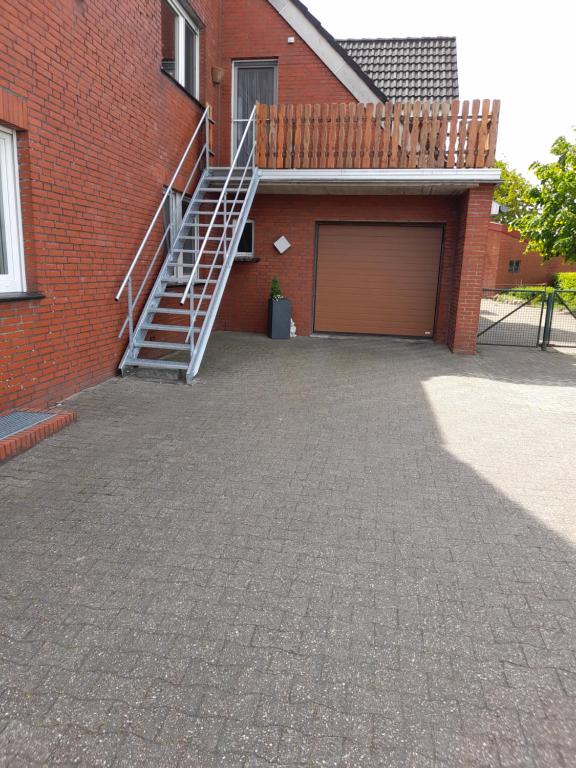a garage with a staircase next to a brick building at Fewo Gr. Berßen 