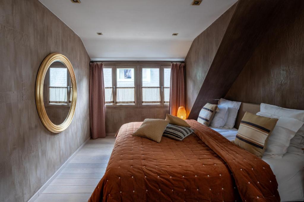 - une chambre avec un grand lit et un miroir dans l'établissement La Petite Ruelle, à Durbuy