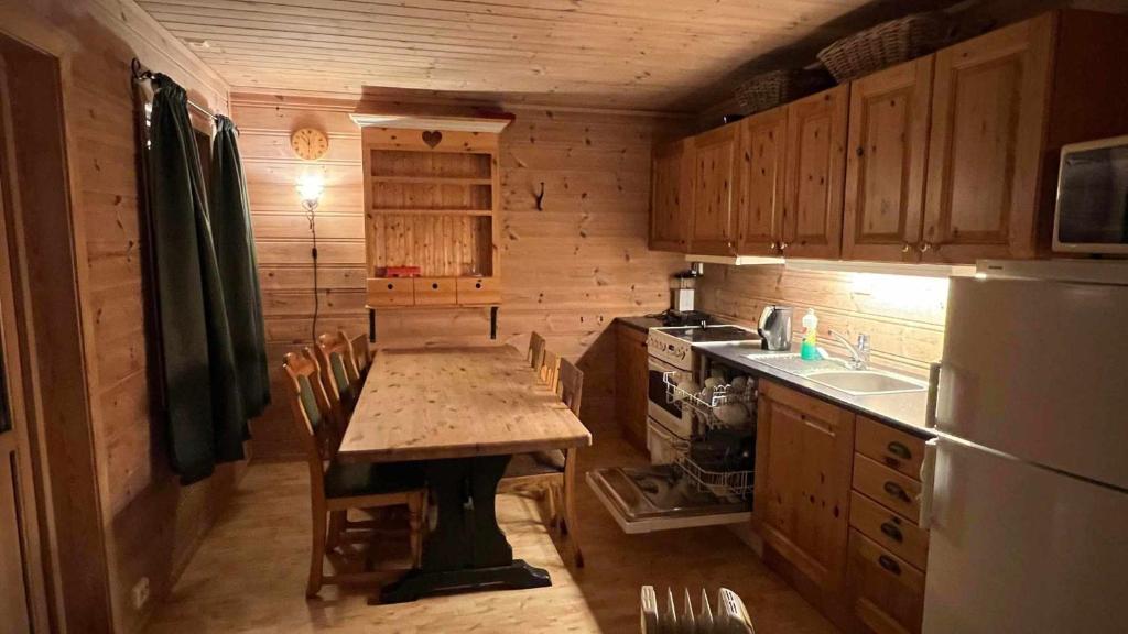 a small kitchen with a table and a refrigerator at Saltvold Hytte Nr8 in Røldal