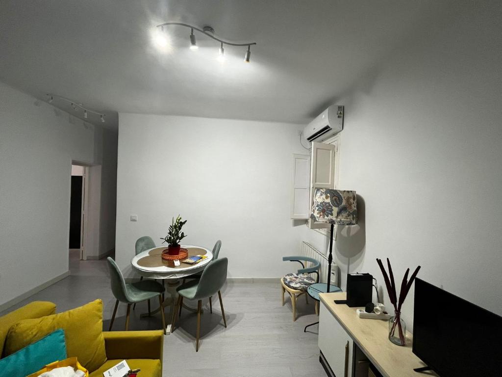 uma sala de estar com uma mesa e cadeiras num quarto em Piso completo a 5 minutos del metro linea 5 verde em Madrid